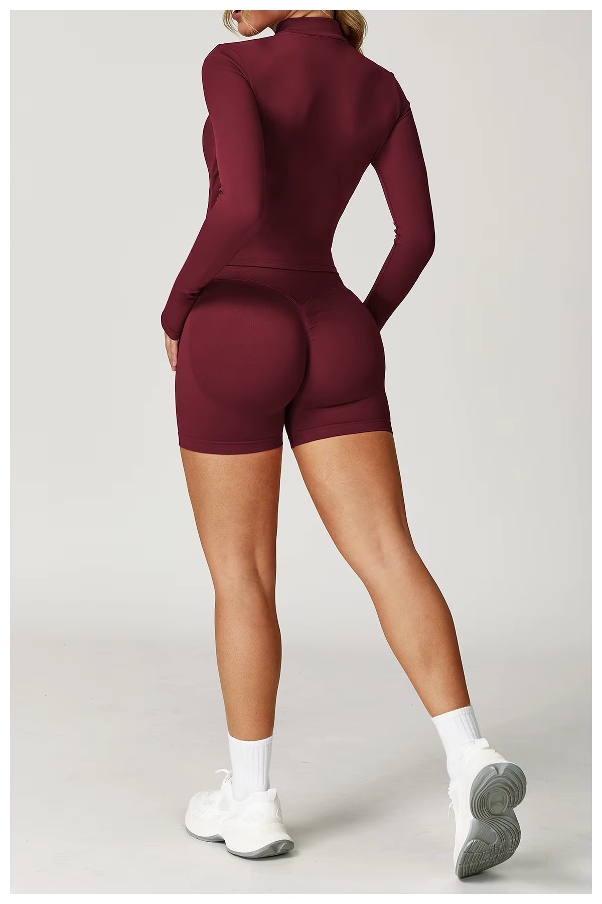 Person wearing a maroon athletic outfit on a light gray background